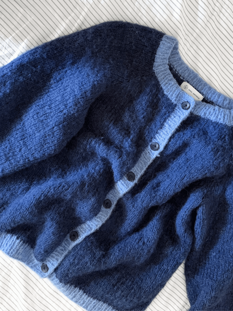 Wełniany sweter ułożony na płasko na materiale